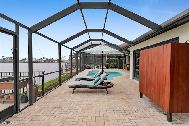 view of patio featuring a water view and glass enclosure