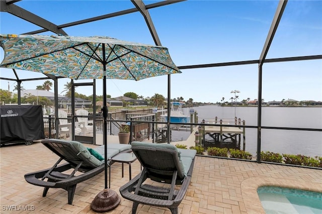 view of patio with area for grilling, a lanai, and a water view