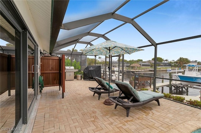 view of patio / terrace featuring a water view, a lanai, area for grilling, and a boat dock