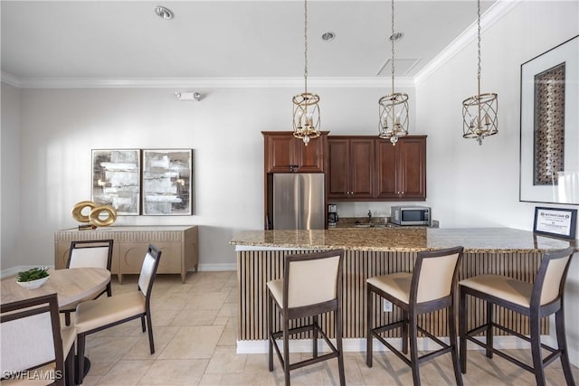 kitchen with stainless steel appliances, dark stone countertops, pendant lighting, and a breakfast bar area