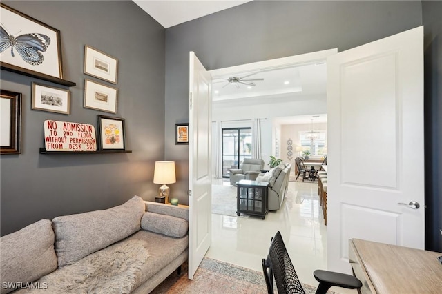 living room featuring a raised ceiling and ceiling fan