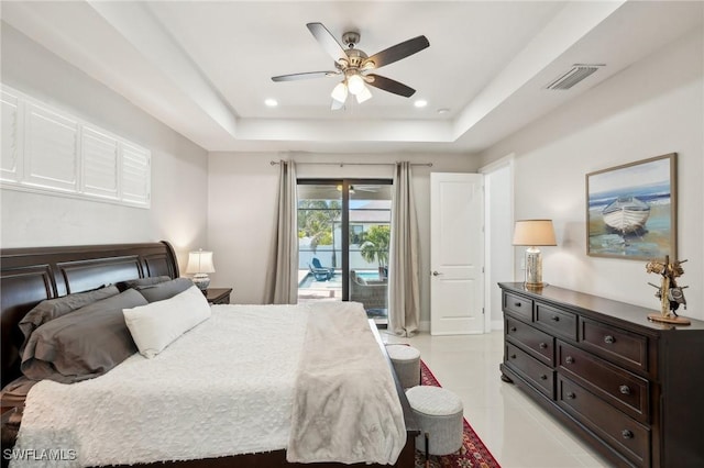 tiled bedroom featuring access to exterior, ceiling fan, and a tray ceiling