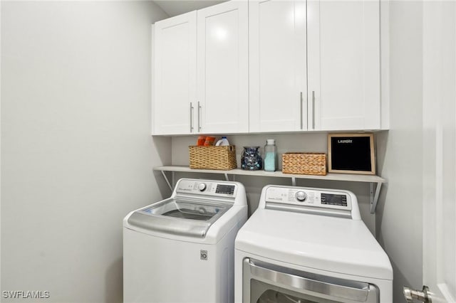 laundry area with cabinets and washer and clothes dryer