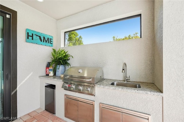 view of patio featuring exterior kitchen, area for grilling, and sink