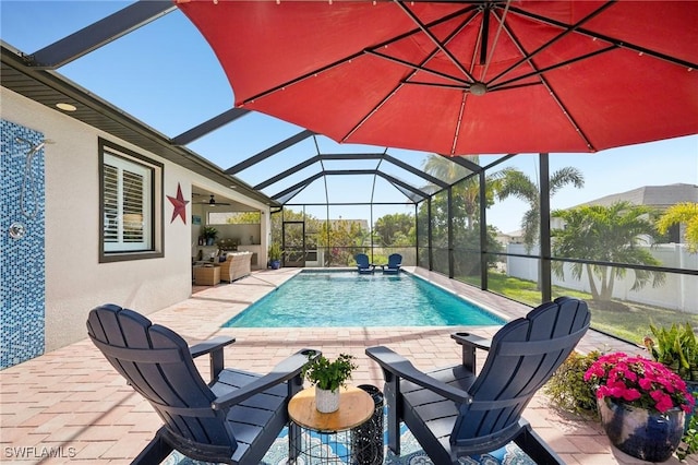 view of pool with ceiling fan, a lanai, exterior kitchen, and a patio