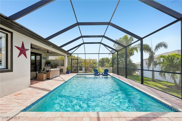 view of swimming pool featuring ceiling fan, an outdoor living space, a patio, and glass enclosure