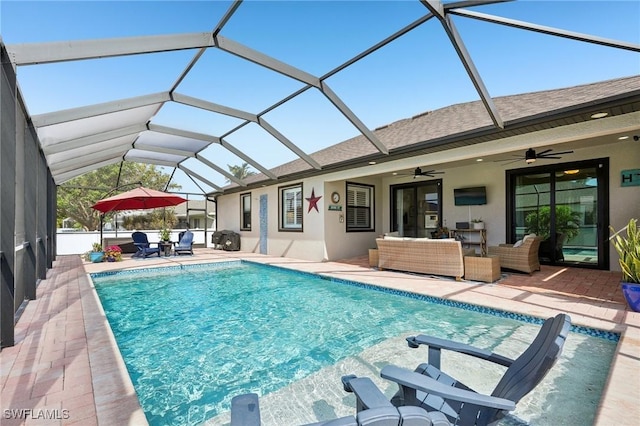 view of pool featuring an outdoor living space, a patio, ceiling fan, and glass enclosure