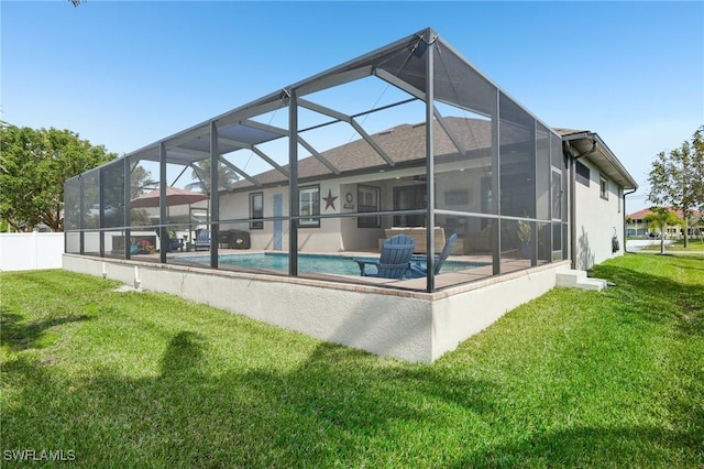 rear view of property featuring a patio, glass enclosure, and a lawn