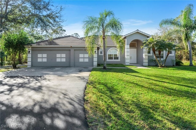 view of front of property with a garage and a front lawn