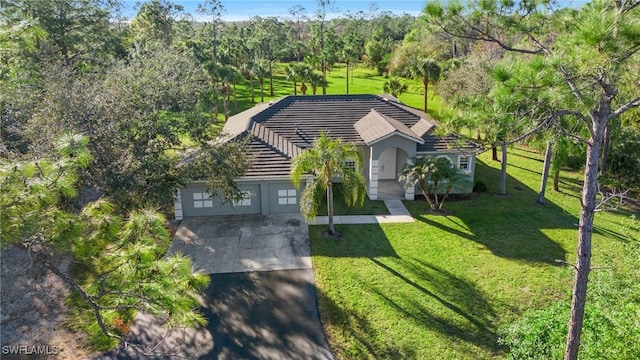 1161 16th St NE, Naples, FL 34120 - view of front of house featuring concrete driveway, a tile roof, an attached garage, a front lawn, and stucco siding