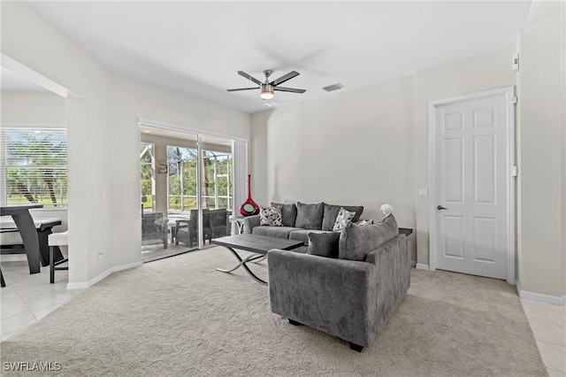 living room featuring ceiling fan, light colored carpet, and a wealth of natural light