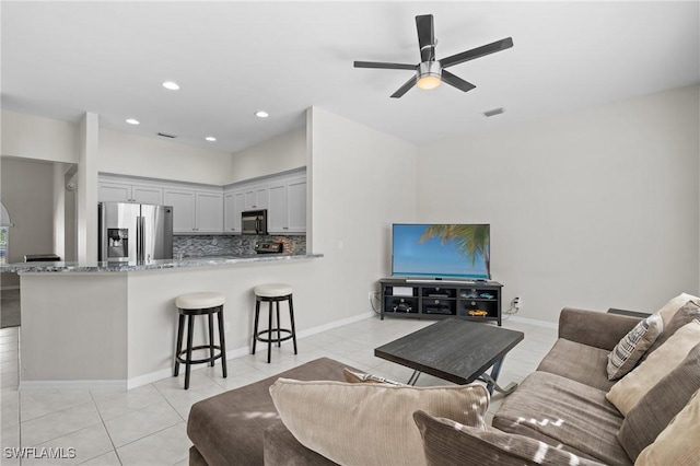 living room featuring ceiling fan and light tile patterned flooring