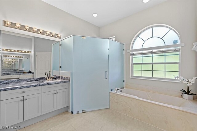 bathroom with vanity, tile patterned floors, and plus walk in shower