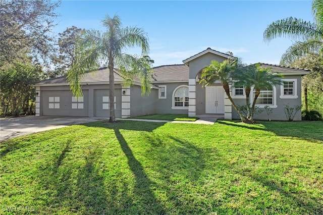 view of front of property with a garage and a front lawn