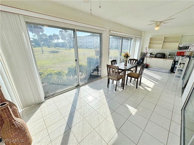 tiled dining space featuring ceiling fan