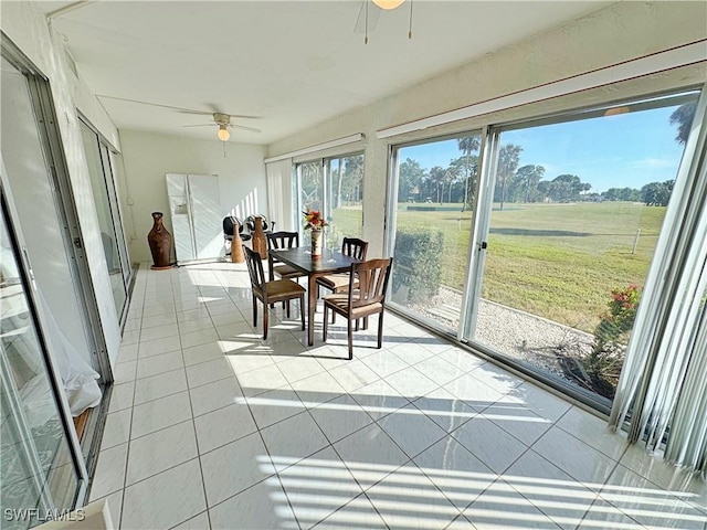 sunroom / solarium with a rural view, plenty of natural light, and ceiling fan