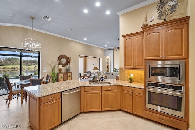 kitchen with sink, light tile patterned floors, appliances with stainless steel finishes, light stone countertops, and kitchen peninsula