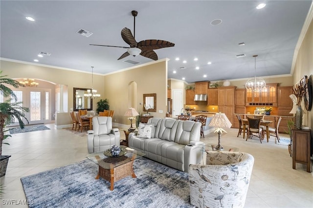 living room with crown molding, ceiling fan with notable chandelier, and light tile patterned floors