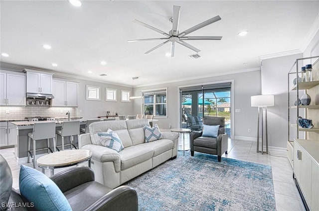 living room featuring crown molding, ceiling fan, and light tile patterned floors