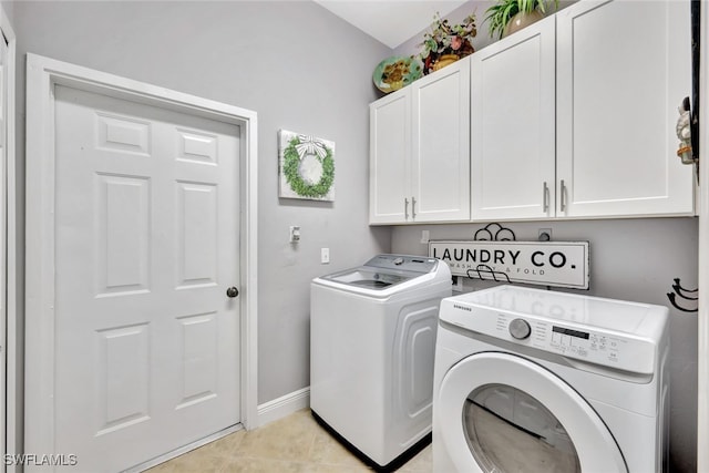 washroom with cabinets, light tile patterned flooring, and washer and dryer