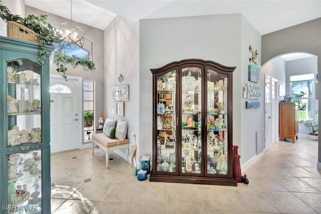 foyer featuring a high ceiling, light tile patterned flooring, and an inviting chandelier