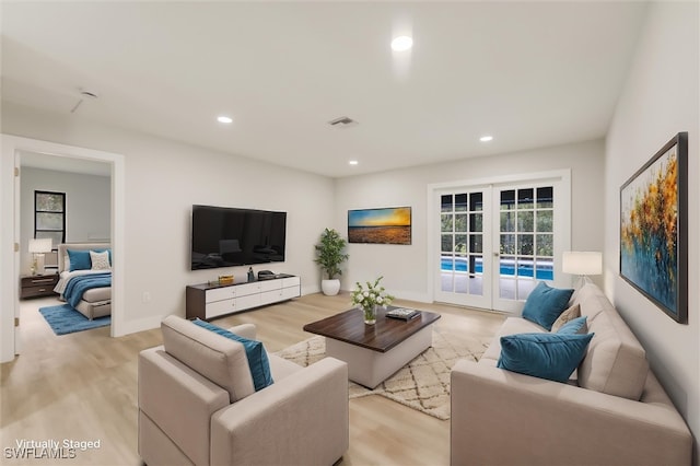 living room with french doors and light wood-type flooring