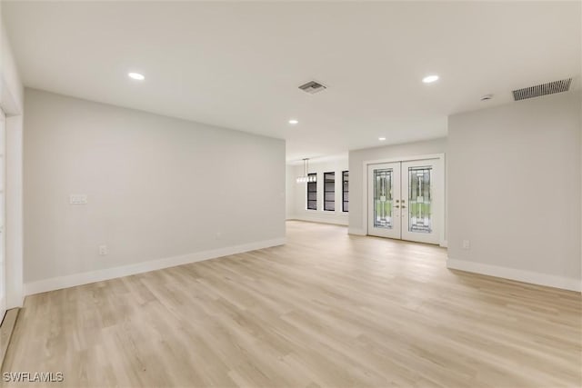 unfurnished living room with french doors and light hardwood / wood-style flooring