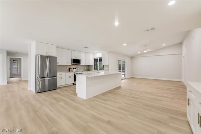 kitchen with backsplash, stainless steel appliances, light hardwood / wood-style floors, and white cabinets