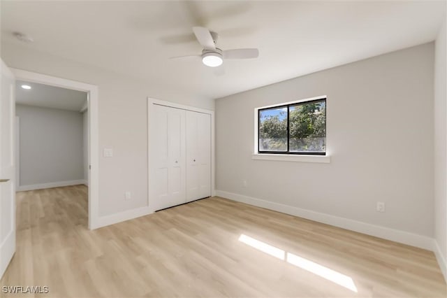 unfurnished bedroom featuring ceiling fan, a closet, and light hardwood / wood-style flooring