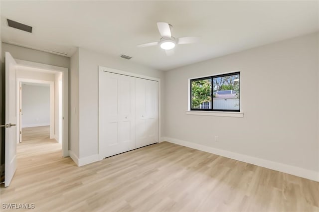 unfurnished bedroom featuring ceiling fan, light hardwood / wood-style floors, and a closet