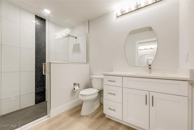 bathroom featuring vanity, hardwood / wood-style floors, toilet, and walk in shower