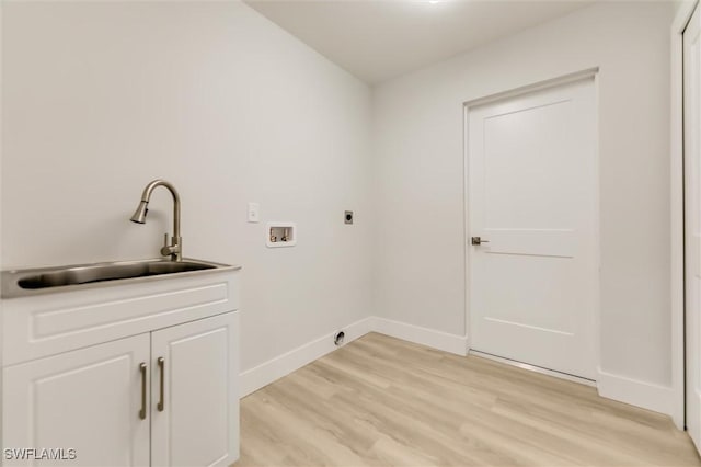 washroom featuring sink, light hardwood / wood-style flooring, hookup for a washing machine, cabinets, and hookup for an electric dryer