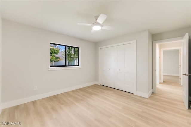 unfurnished bedroom featuring ceiling fan, a closet, and light hardwood / wood-style flooring