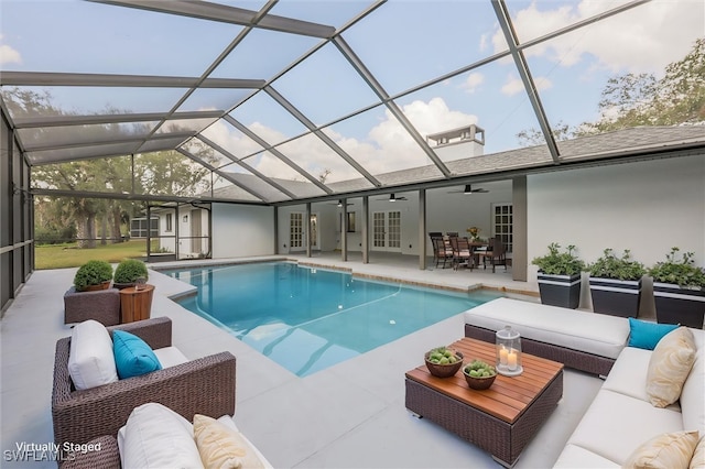 view of swimming pool with a patio, outdoor lounge area, a lanai, ceiling fan, and french doors