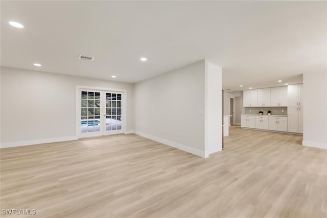 unfurnished living room featuring light hardwood / wood-style flooring and french doors