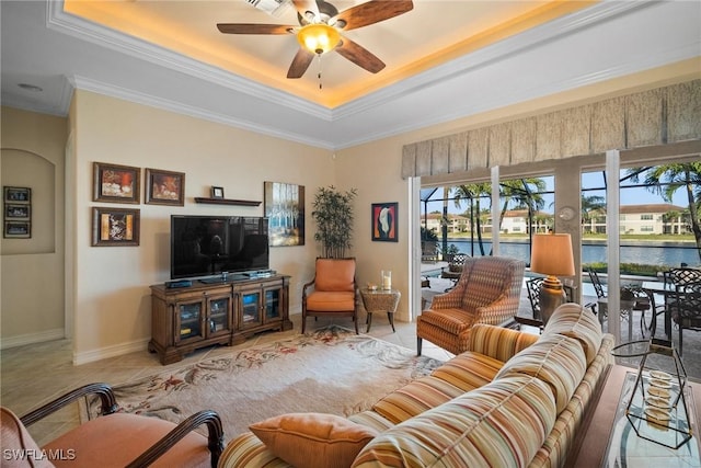 living room with crown molding, ceiling fan, a raised ceiling, and light tile patterned floors