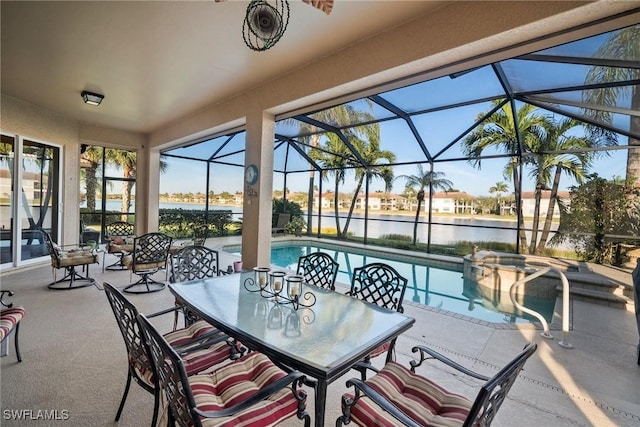 view of patio featuring a swimming pool with hot tub, glass enclosure, and a water view