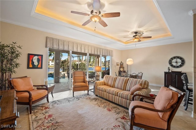 living room with crown molding, light tile patterned floors, ceiling fan, and a tray ceiling