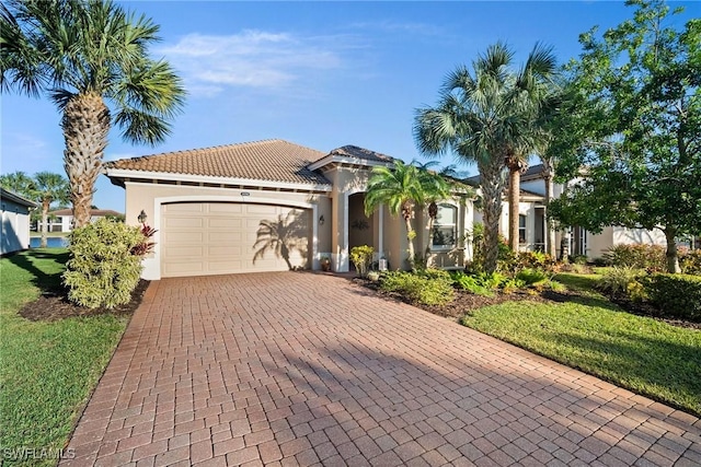 mediterranean / spanish-style home featuring a garage and a front yard