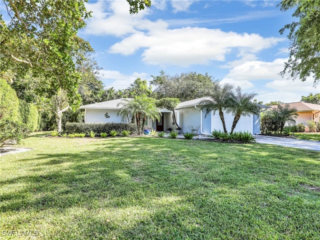 ranch-style house with a garage and a front lawn