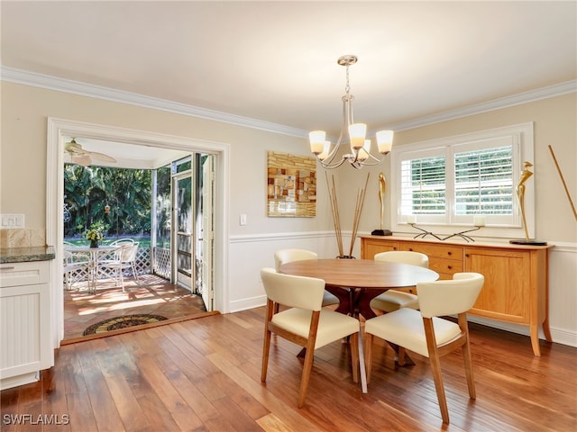 dining room featuring hardwood / wood-style flooring, ornamental molding, and an inviting chandelier