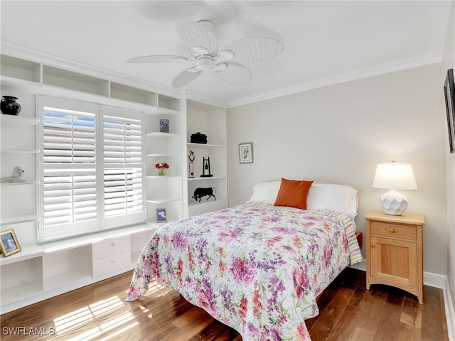 bedroom featuring dark hardwood / wood-style flooring, built in desk, ornamental molding, and ceiling fan