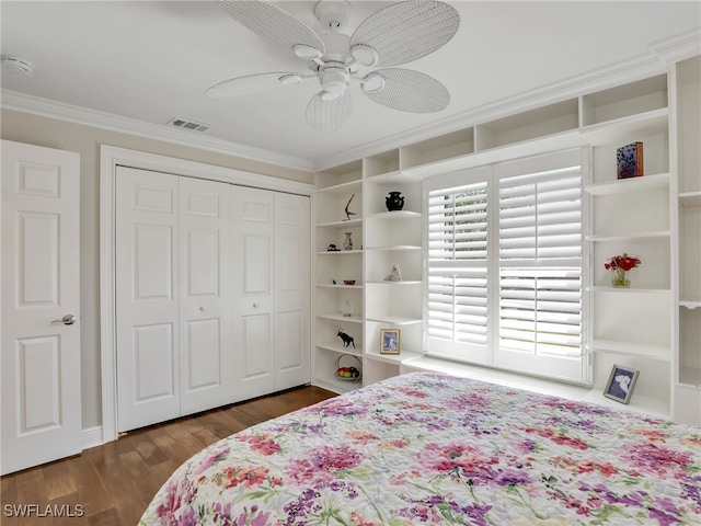 bedroom featuring crown molding, dark wood-type flooring, ceiling fan, and a closet