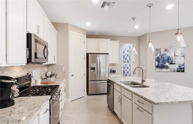 kitchen featuring sink, white cabinetry, hanging light fixtures, a center island with sink, and stainless steel appliances