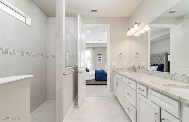 bathroom with vanity and tiled shower