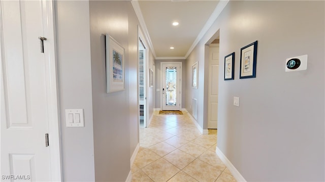 hall featuring ornamental molding and light tile patterned flooring