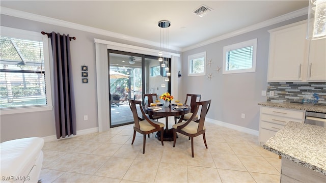 dining area with crown molding and light tile patterned floors