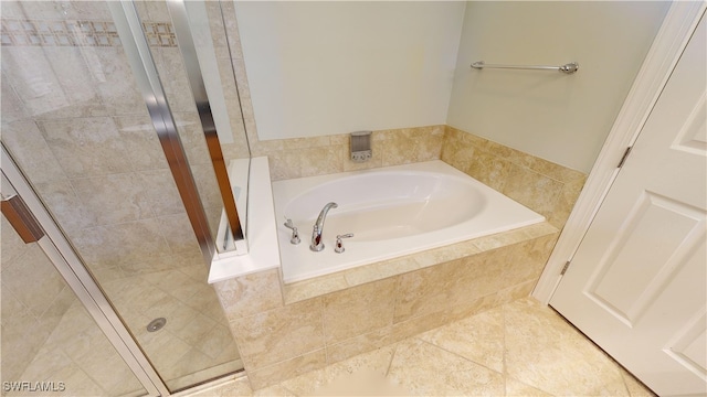 bathroom featuring tile patterned floors and tiled bath