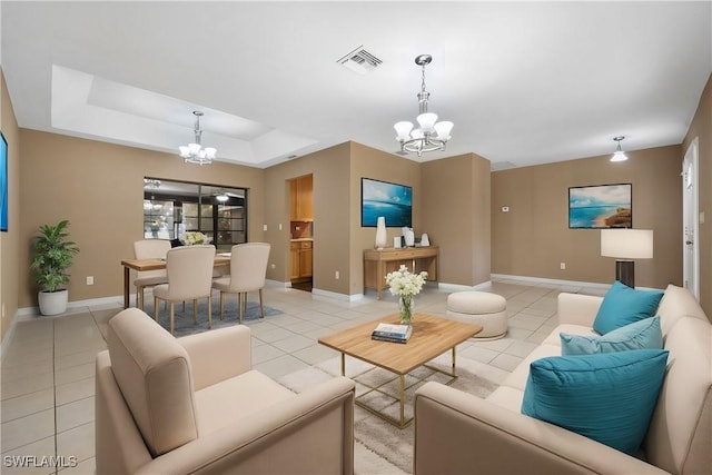 living room with a notable chandelier, a raised ceiling, and light tile patterned flooring