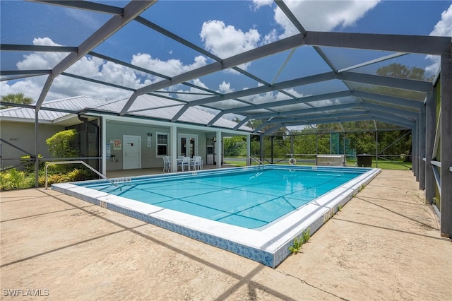 view of swimming pool with a lanai, a patio area, and french doors